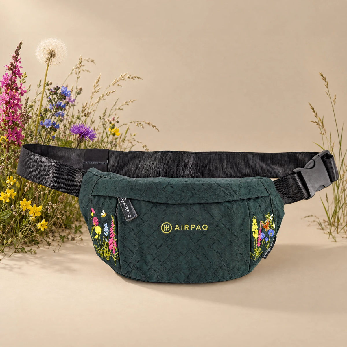 Hip Baq Large Robinga-Edition Auflage 2 – Frontansicht mit Blumenstickerei auf sandfarbenem Hintergrund